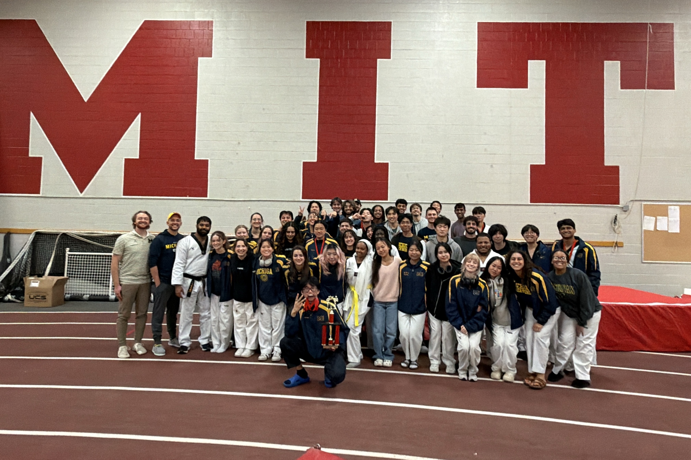 Michigan Taekwondo teammates gathered with a competition trophy